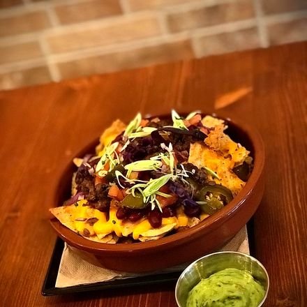 Nachos con carne picada, salsa cheddar y guacamole en cazuela de barro.
